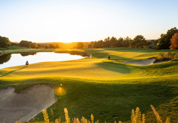 WINSTONgolf Grün 2 im Sonnenuntergang Golfer spielt gleich zur Fahne